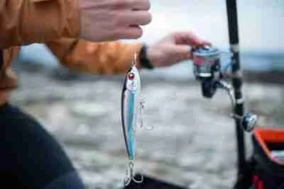 Close-up of man preparing fishing lures for shore fishing.He is getting ready for casting.