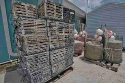 Crab traps, ropes and buoys stacked beside a warehouse in Tarpon Springs, FL.