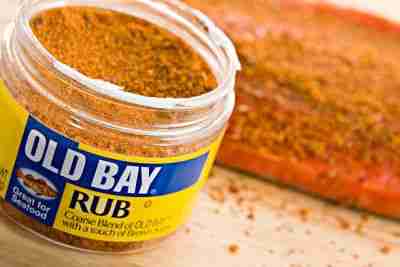 Chico, California, USA - March 23,2011 : A 3.8 OZ plastic Jar of Old Bay Rub with an out of focus piece of salmon treated with the rub in the background. This fine rub is a product of Canada- Maryland based Old Bay was originally known as Delicious Brand Shrimp and Crab Seasoning