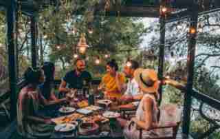 Group of friends having a summer dinner party on the patio