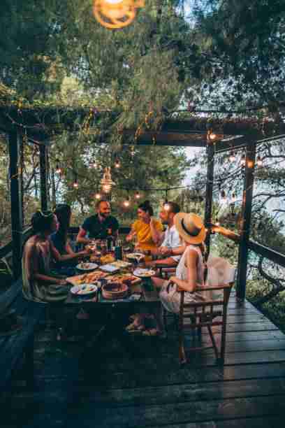 Group of friends having a summer dinner party on the patio