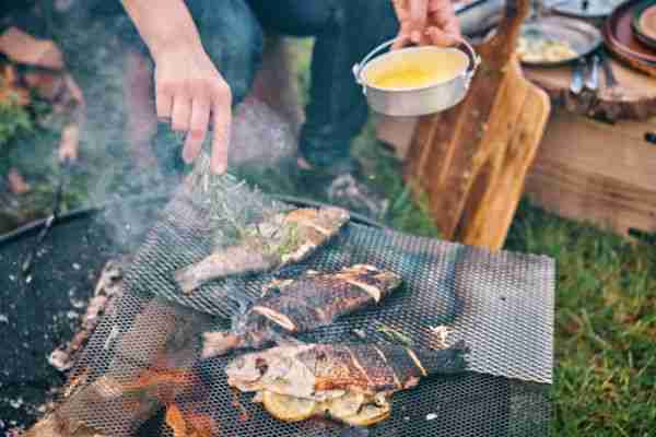 Cooking Fish with Lemon Over Open Campfire